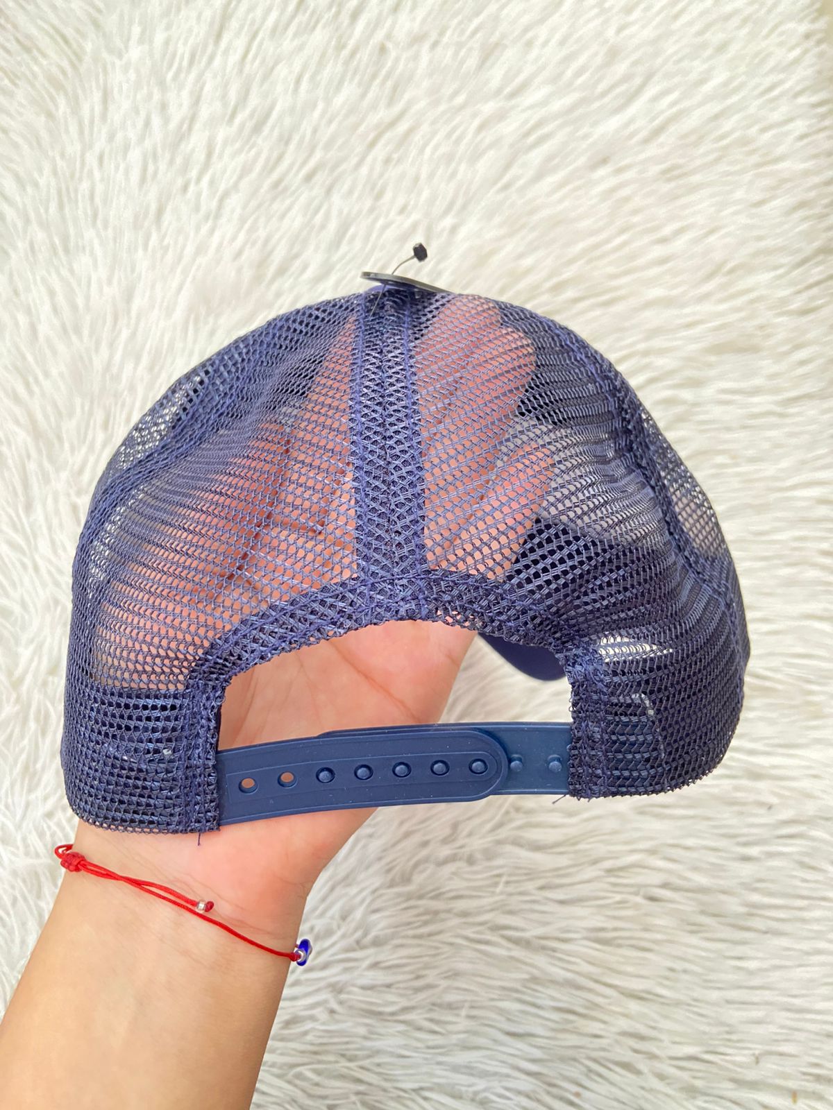 Gorra, azul marino con malla en la parte trasera y letras NIRVANA NEVER MIND en blanco.