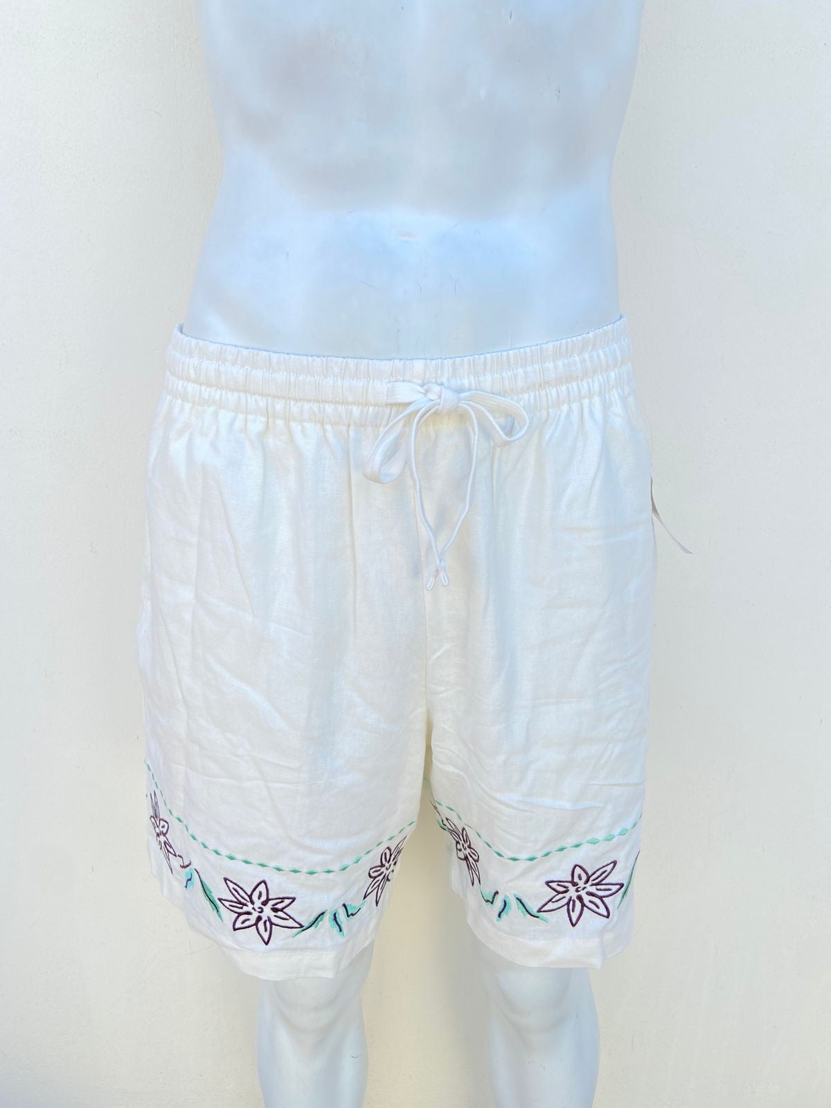 Bermuda Forever 21 original blanca con flores bordadas en la parte inferior.