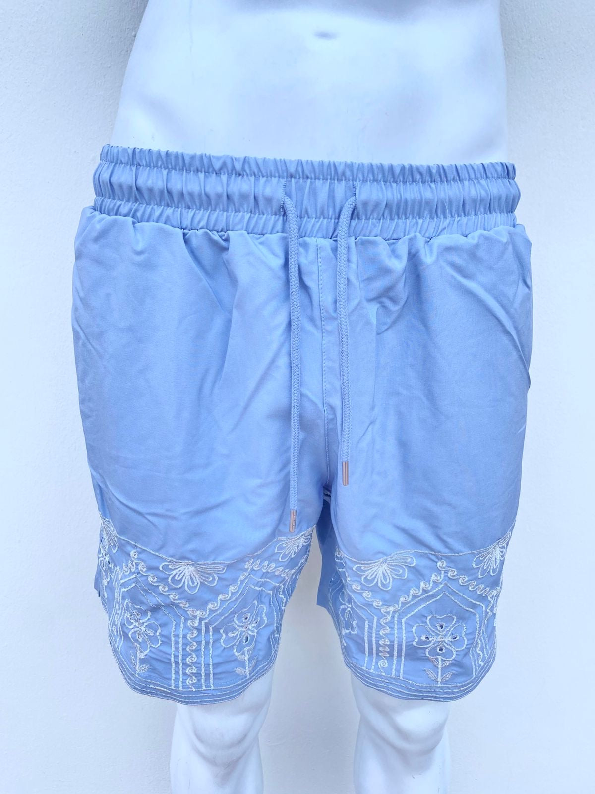 Bañador Baggy azul con detalles abajo en color blanco.