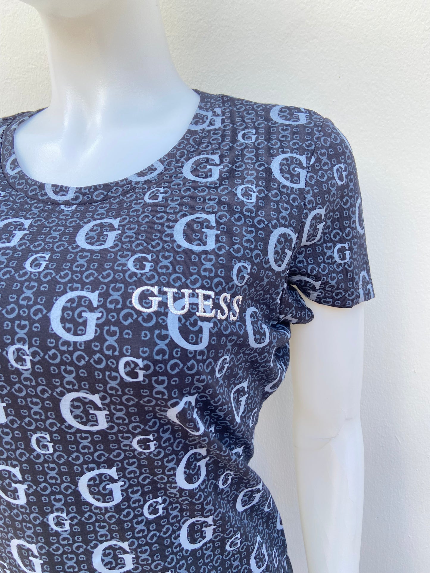 T-shirt GUESS original, negro con estampado de letras G en color gris.
