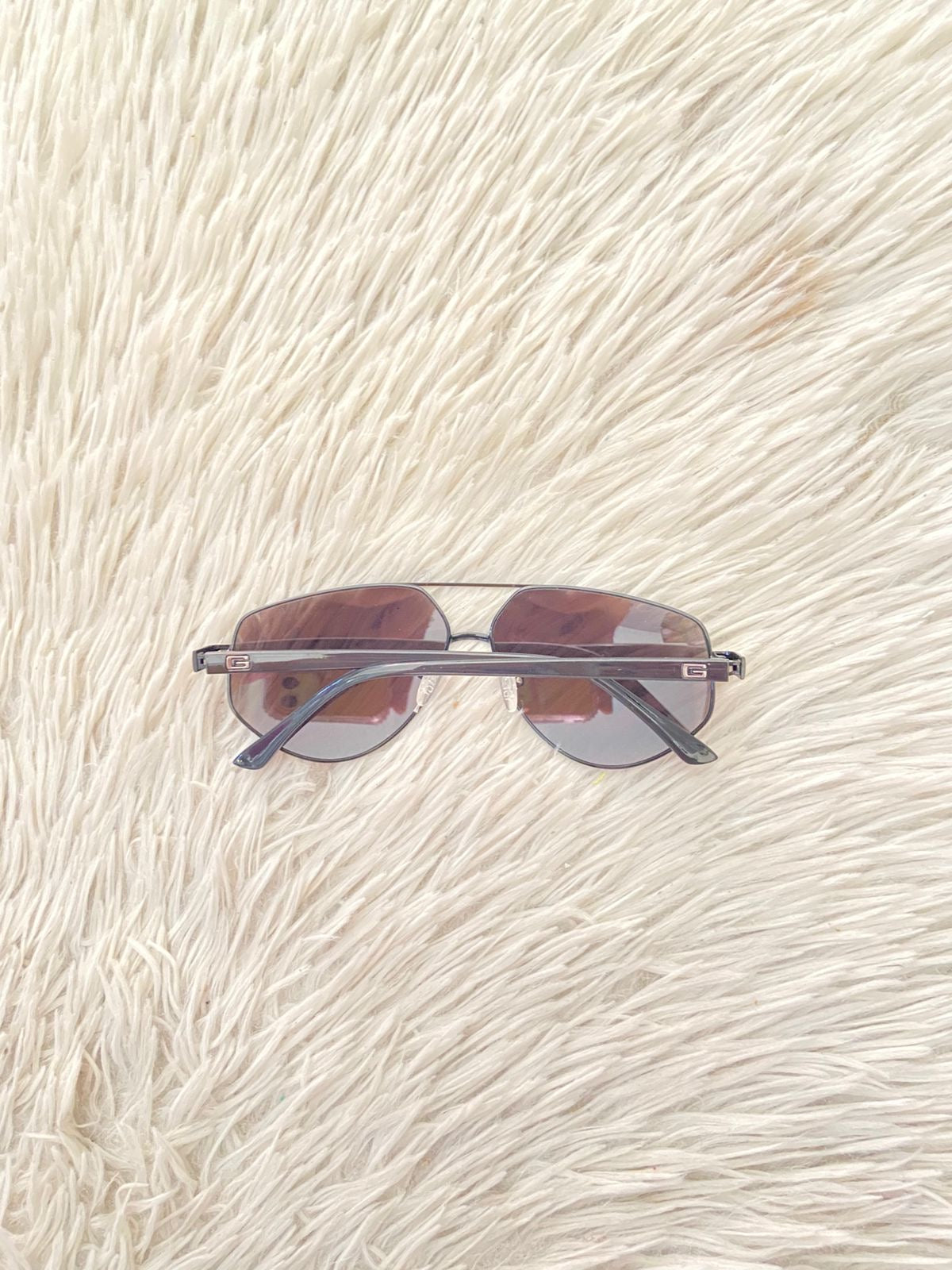 Lentes GUESS Original en color negro con micas oscuras y letra G atras.