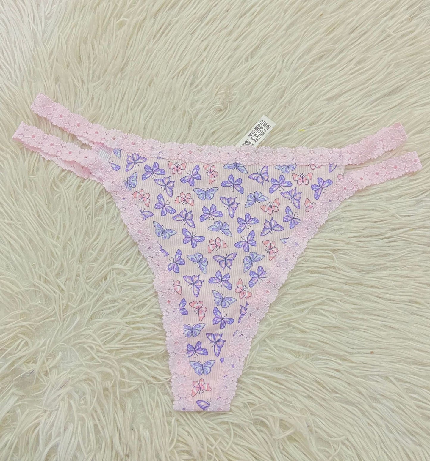 Panti PINK original rosado en encaje con estampado de mariposas moradas.