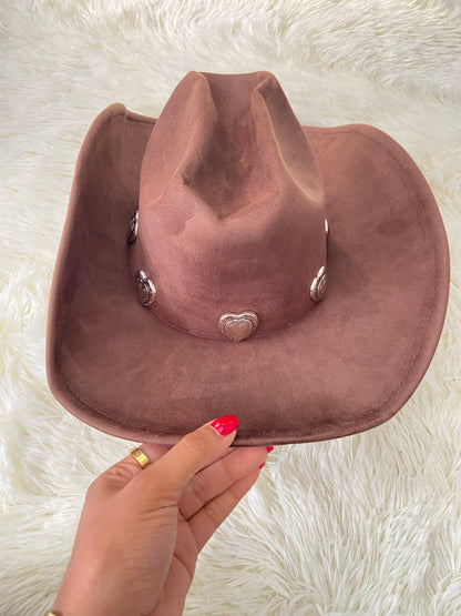 Sombrero, marron oscuro con placas de corazón al rededor en plateado, estilo vaquero.