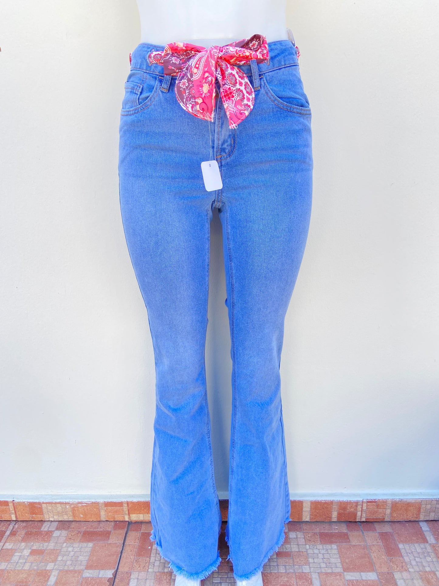 Pantalon Jean, azul claro, estilo campana, con lazo en color rosado.