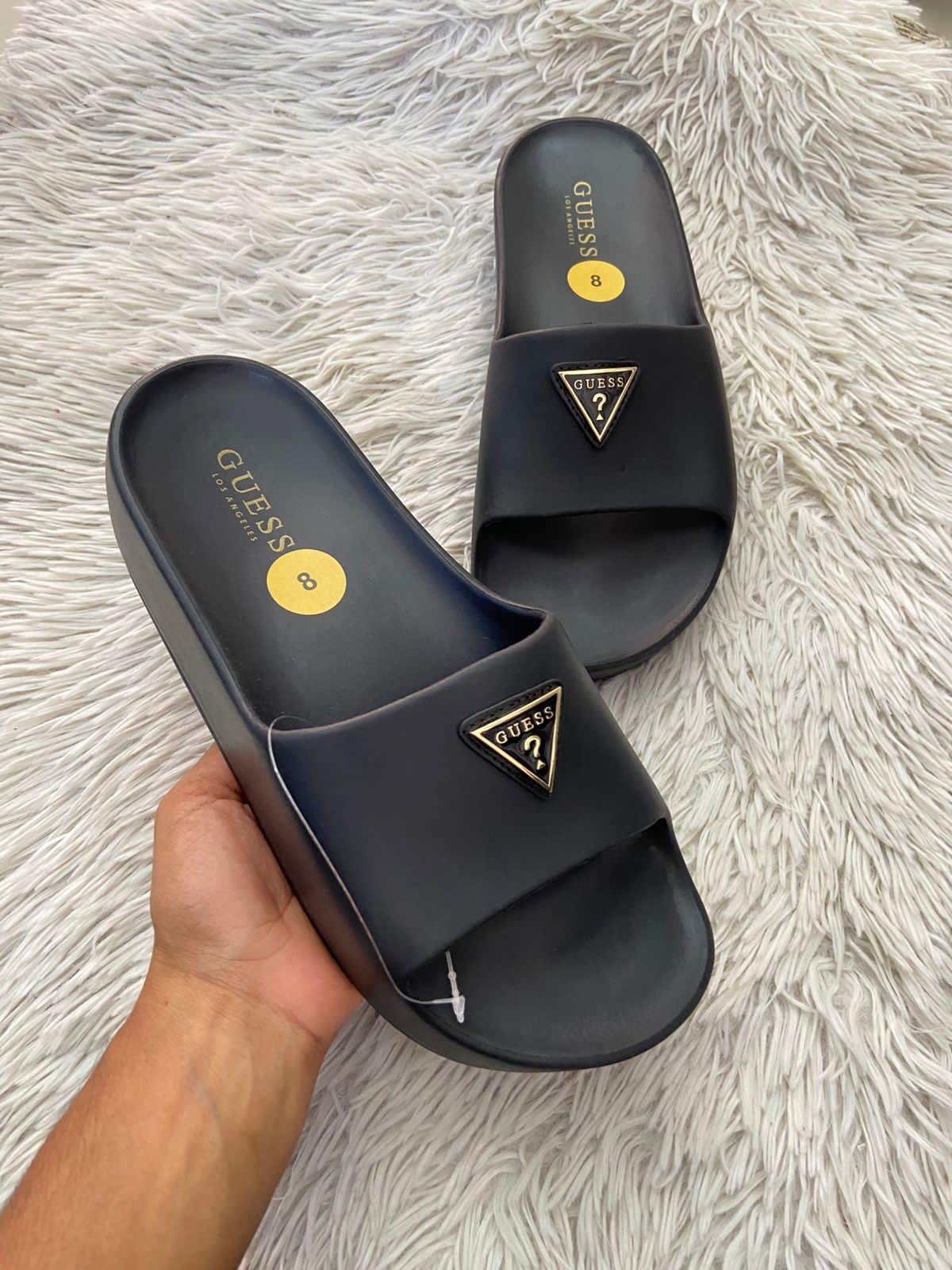 Sandalias GUESS original, negra con plataformas y placa GUESS en frente en color dorado y negro.