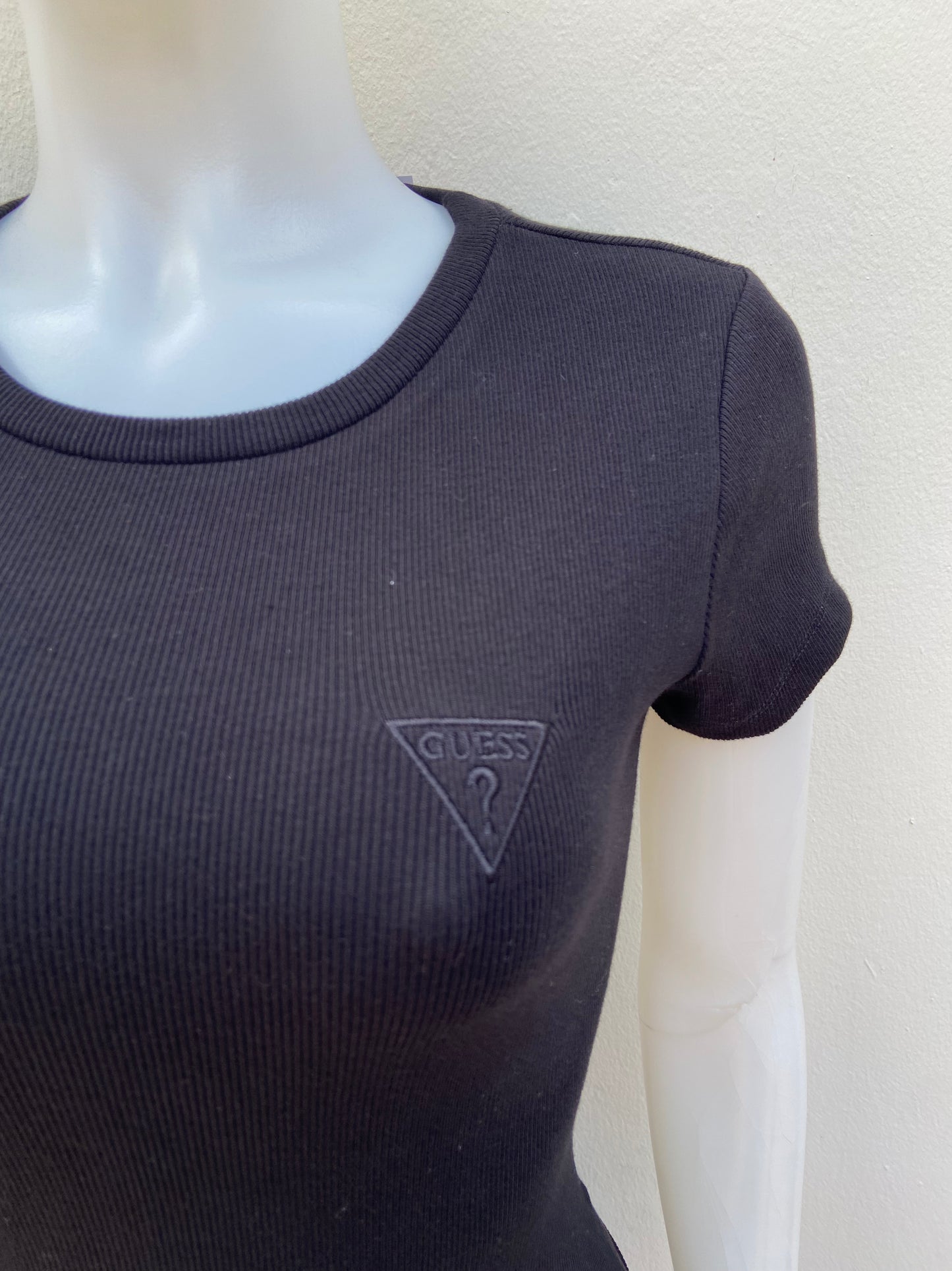 T-shirt GUESS original, negro liso con triángulo en color negro y letras GUESS? en la esquina.