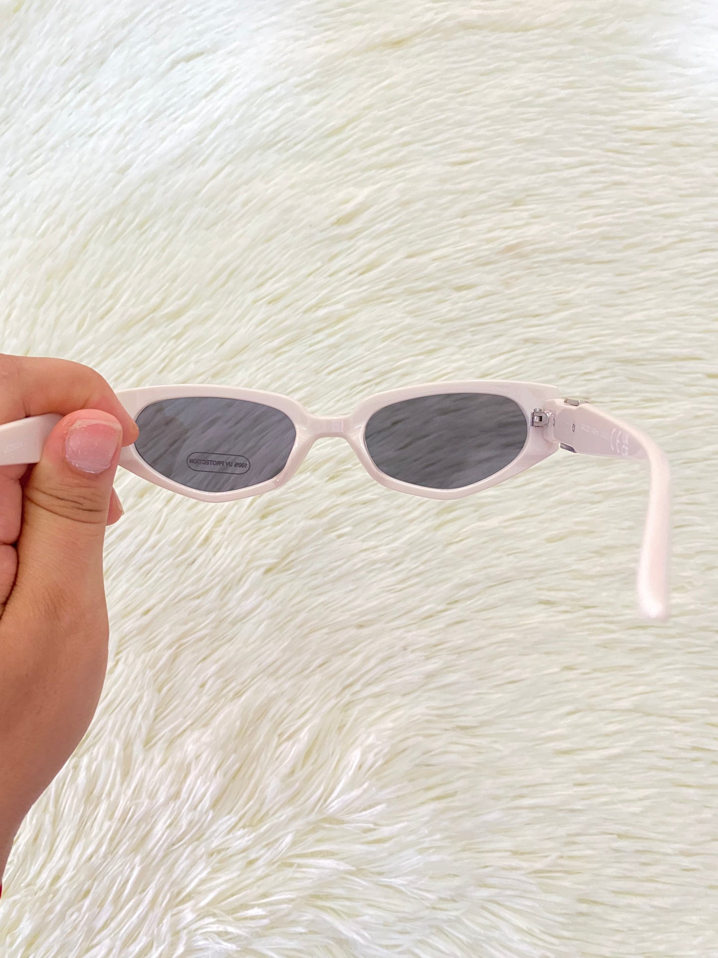 Lentes color blanco/hueso con micas oscuras con detalle plateado con negro atrás.
