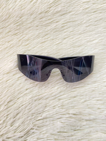 Lentes, negros curvos con detalles plateados en la montura.