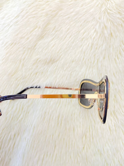 Lentes, negro con detalles en color dorado en frente y montura fina.