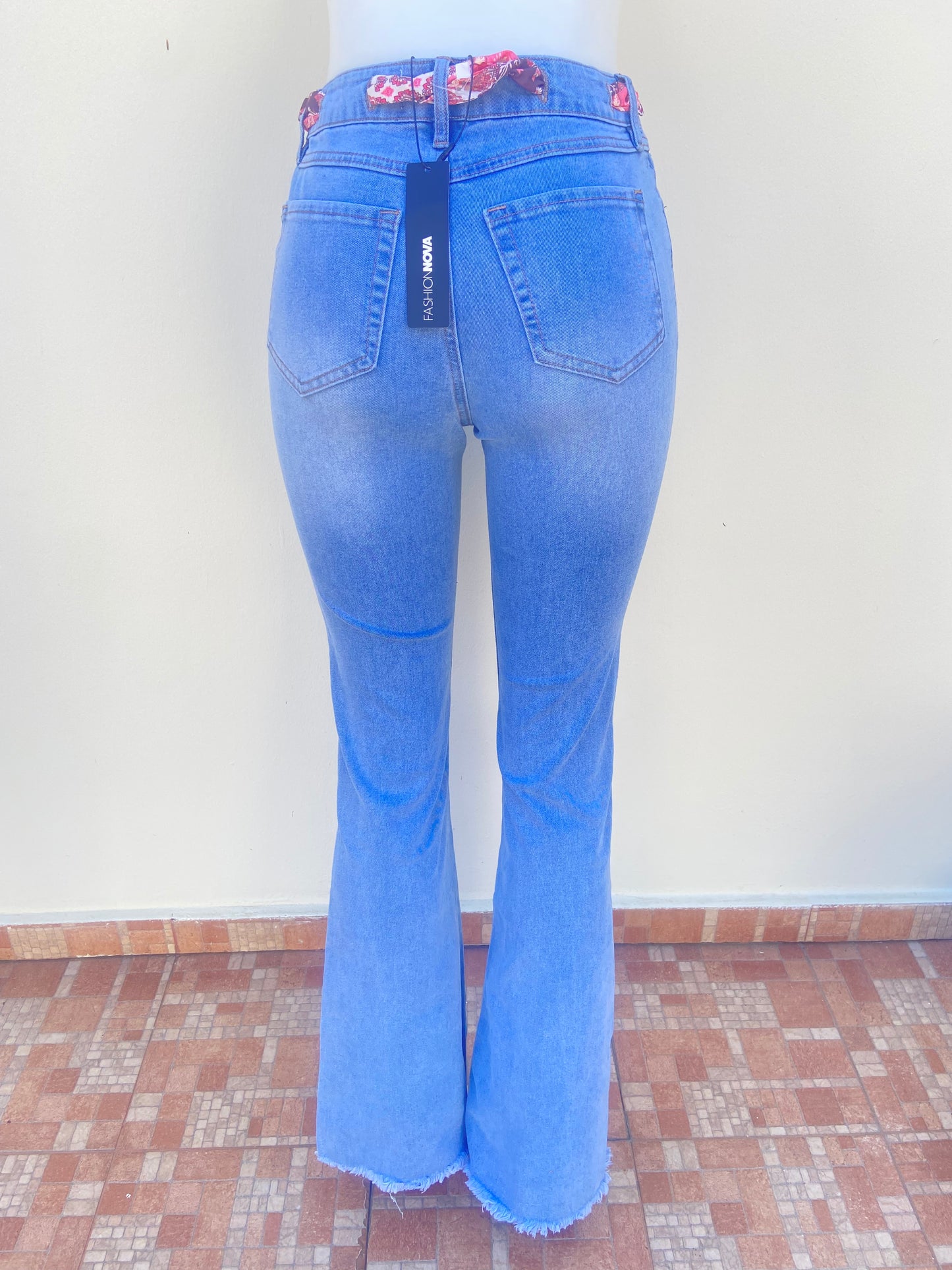 Pantalon Jean, azul claro, estilo campana, con lazo en color rosado.
