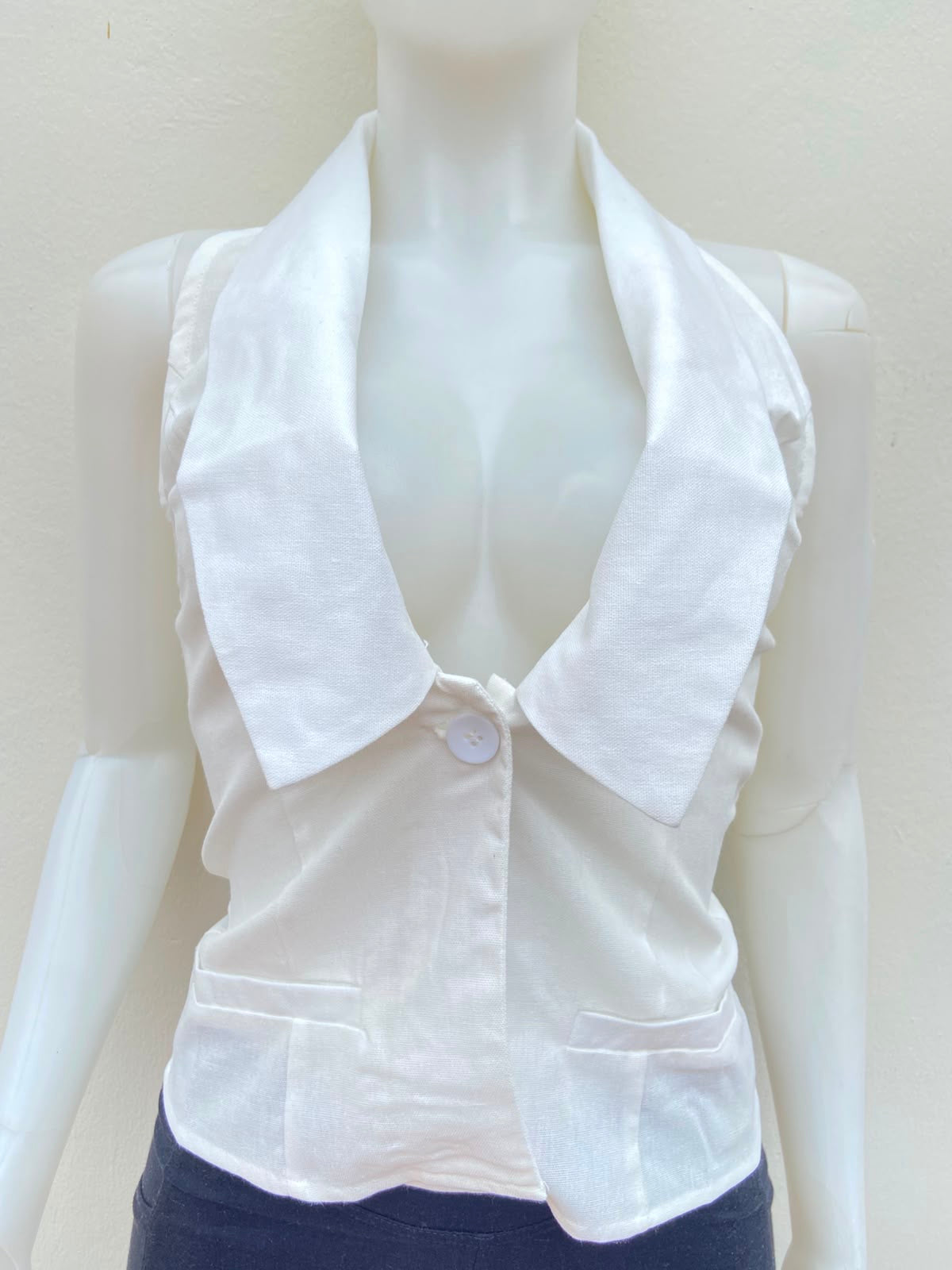Top blanco con cuello estilo camisa, descostado atras.
