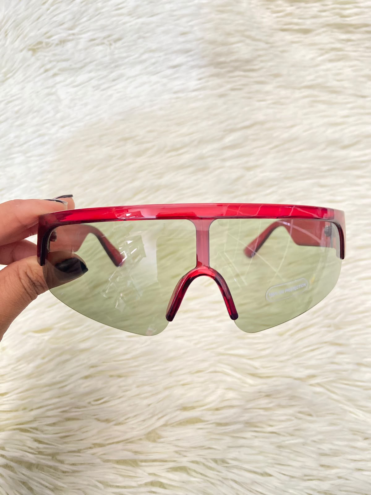 Lentes, verde oliva con montura en rojo vino y micas claras, con protección UV 100%.