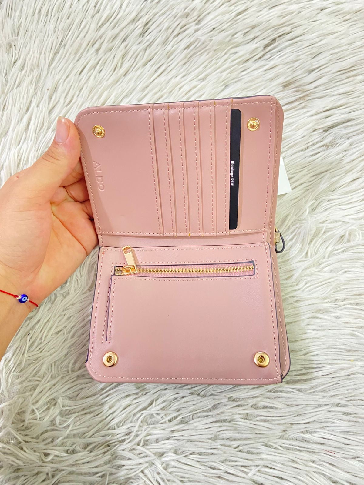 Monedero/ Cartera ALDO Original en color crema con placa de la marca al frente en color dorado y llavero adicional.