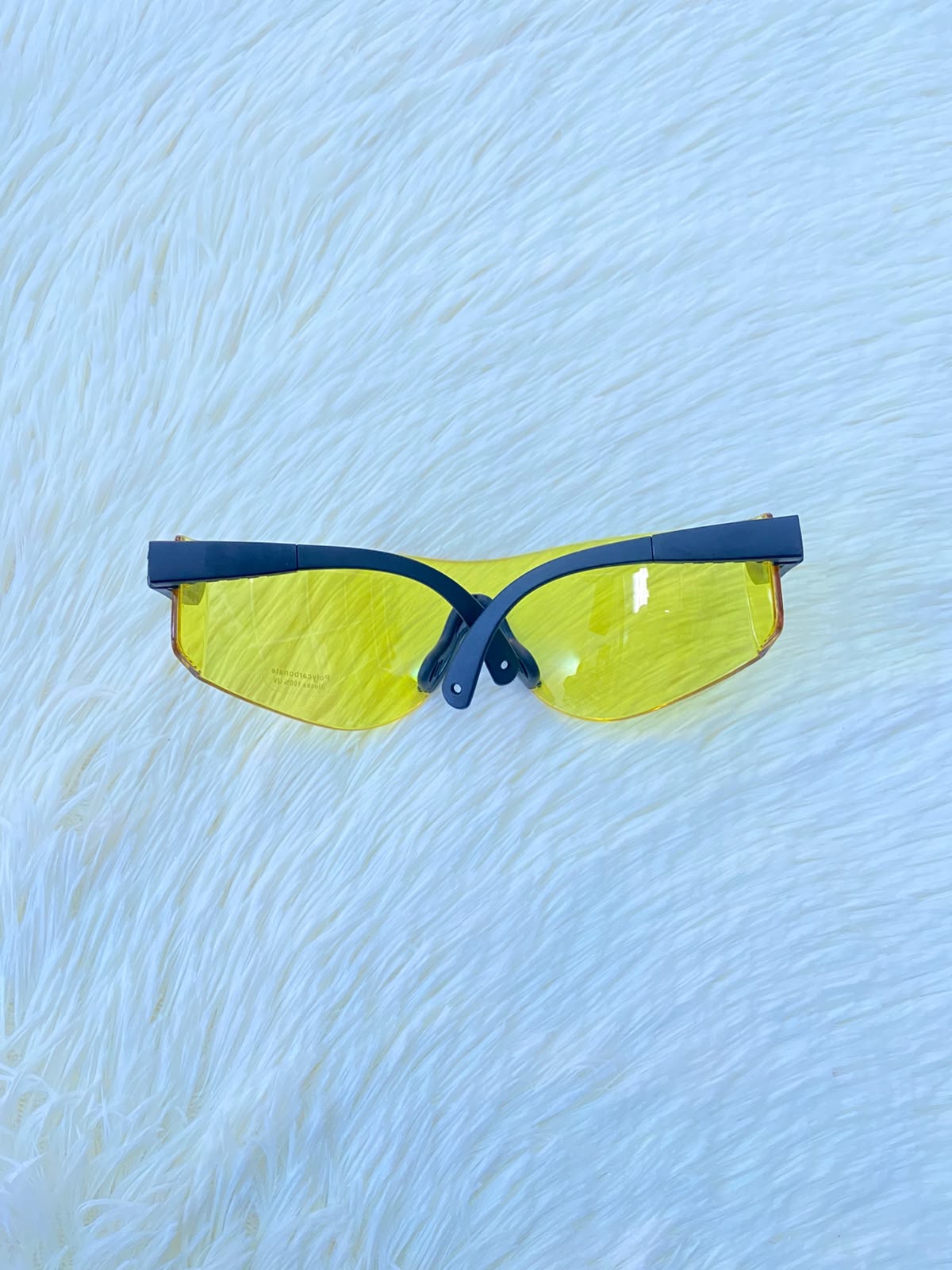 Lentes, sin montura con micas en color amarillo y patillas negras.