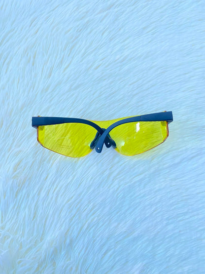 Lentes, sin montura con micas en color amarillo y patillas negras.