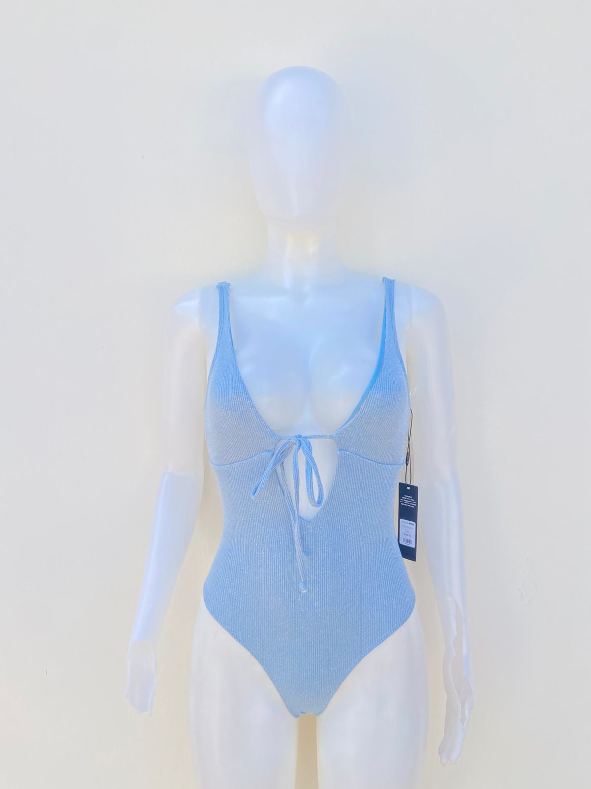 Biquini de una pieza en color azul con tela brillante con abierto ajustable al frente y un poco descubierto atras.