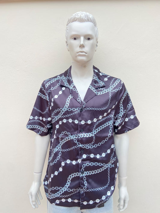 Camisa negra, con estampado de cadenas y perlas.
