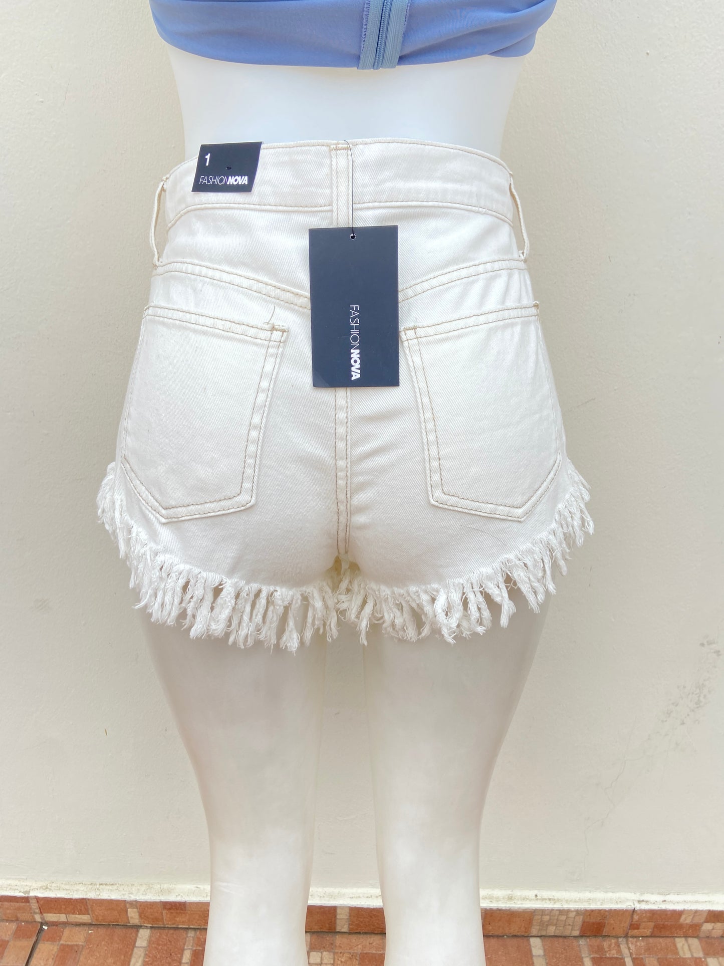 Short Fashion Nova original blanco hueso con ruedo destruido.