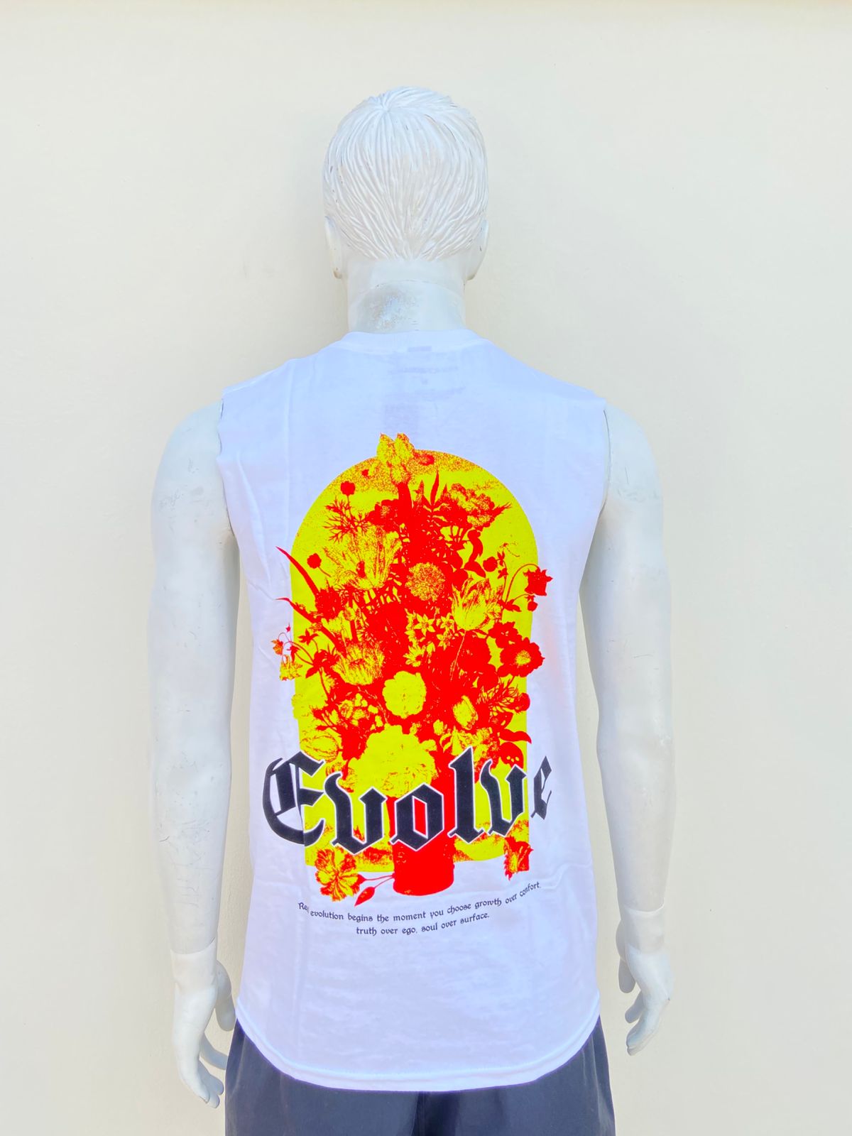 Franela blanca con letra en color negra al frente EVOLVE y diseño atras.