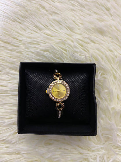 Reloj, dorado con detalles de  diamantes.