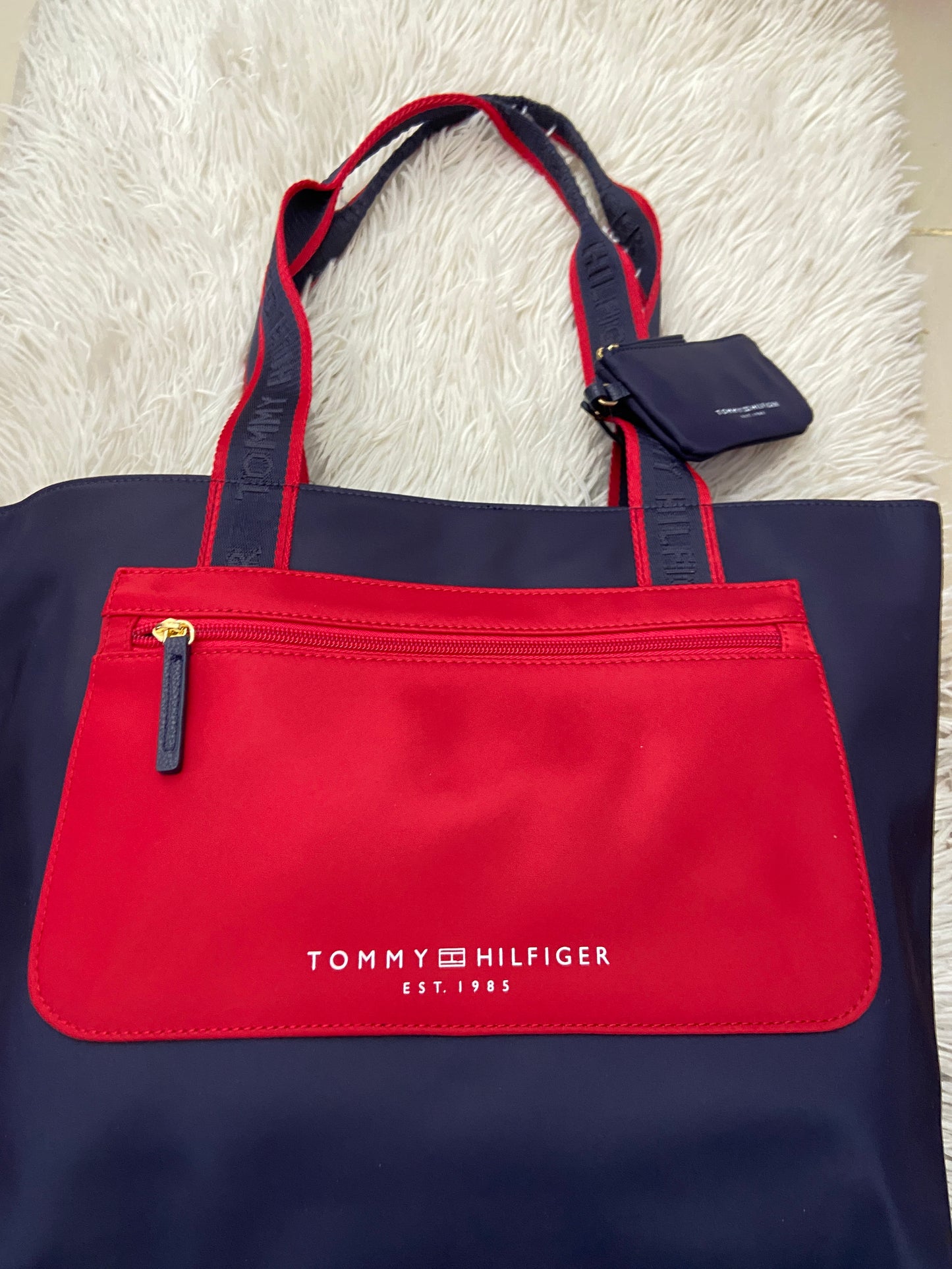 Cartera Tommy Hilfiger original azul marino con rojo y letras TOMMY HILFIGER en blanco.