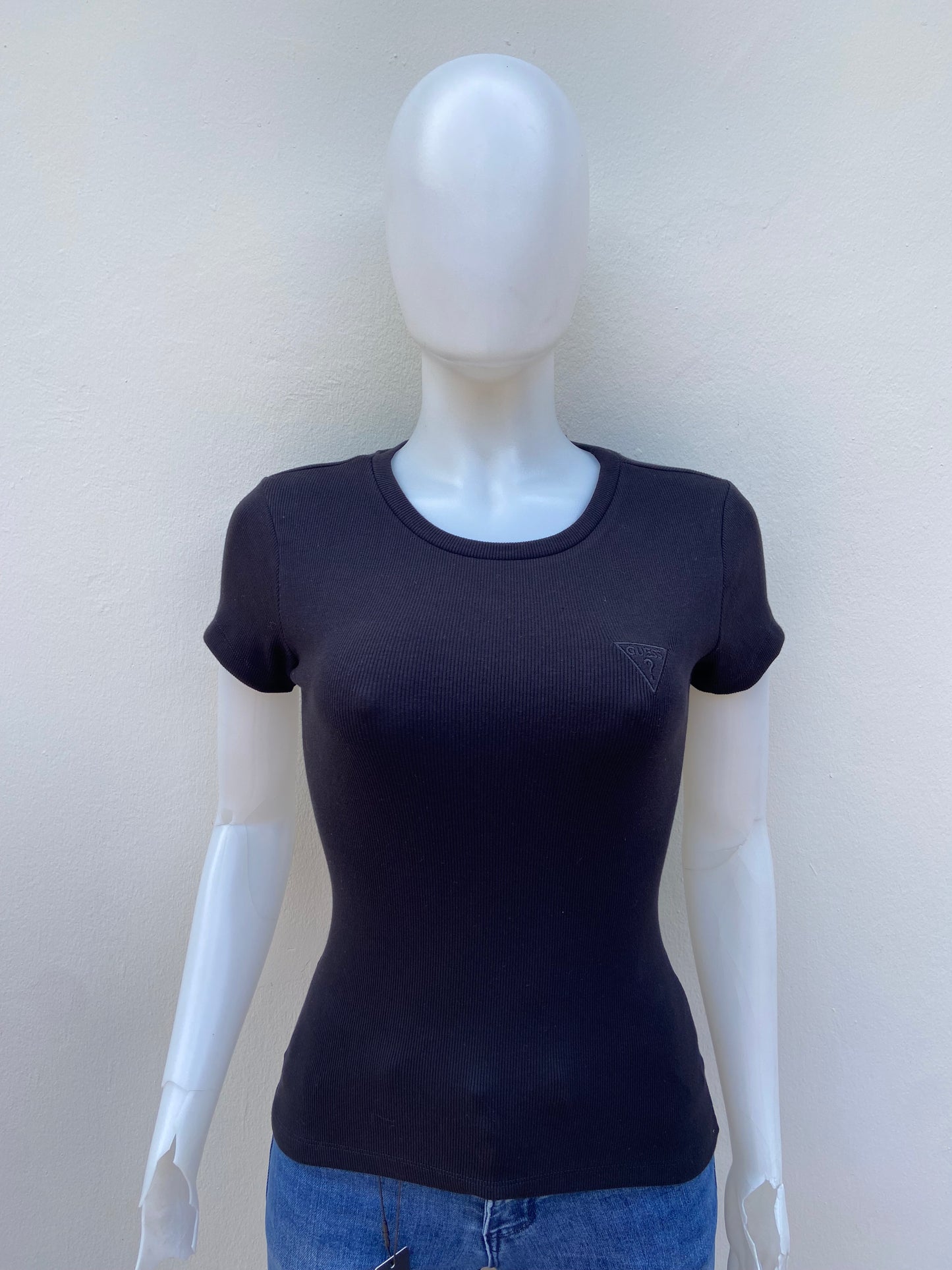 T-shirt GUESS original, negro liso con triángulo en color negro y letras GUESS? en la esquina.