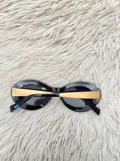 Lentes, diseñados con protección UV 100-400 para proteger tu visión. Negro con montura en dorado y micas en forma de óvalo.