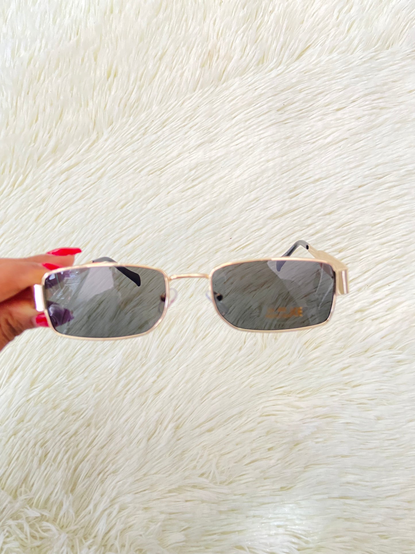 Lentes, negros con montura en color dorado, pequeños con protección UV 400.