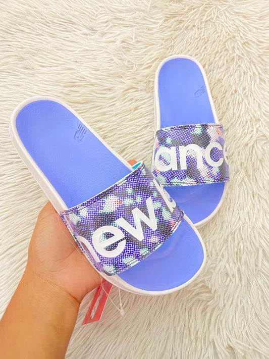 Sandalias NEW BALANCE original, azul claro con blanco y letras de la marca en frente.