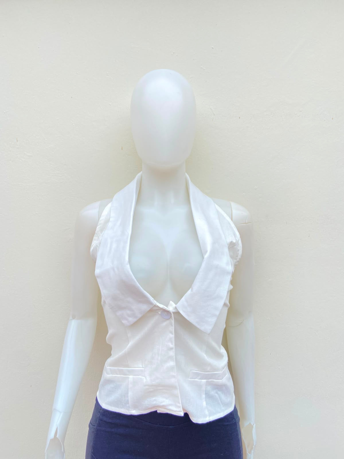 Top blanco con cuello estilo camisa, descostado atras.