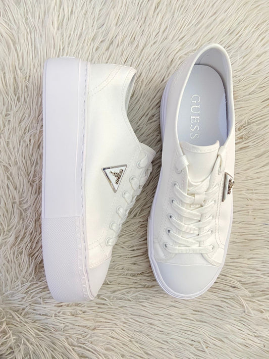 Tenis GUESS Original, en color blanco con placa de la marca al lado en color plateado, plataforma.