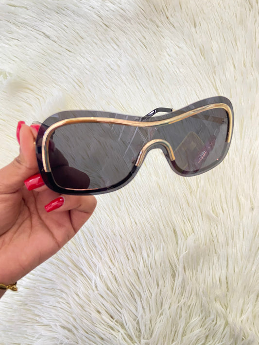 Lentes, negros, grandes curvos, con línea dorada al rededor y montura en  dorado.