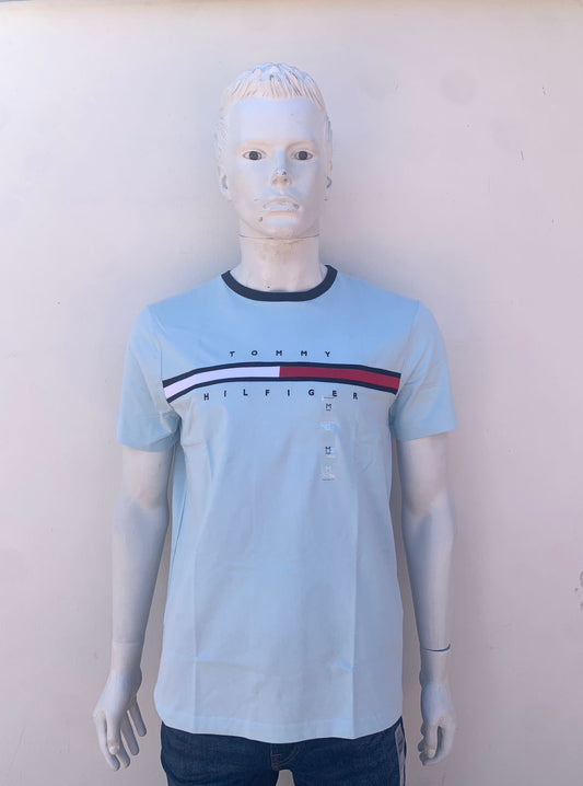 T-shirt Tommy Hilfiger original azul claro con bandera Tommy en frente.