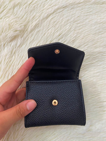 Monedero pequeño negro con diseño al frente en color dorado, cierre de boton y súper espacioso.