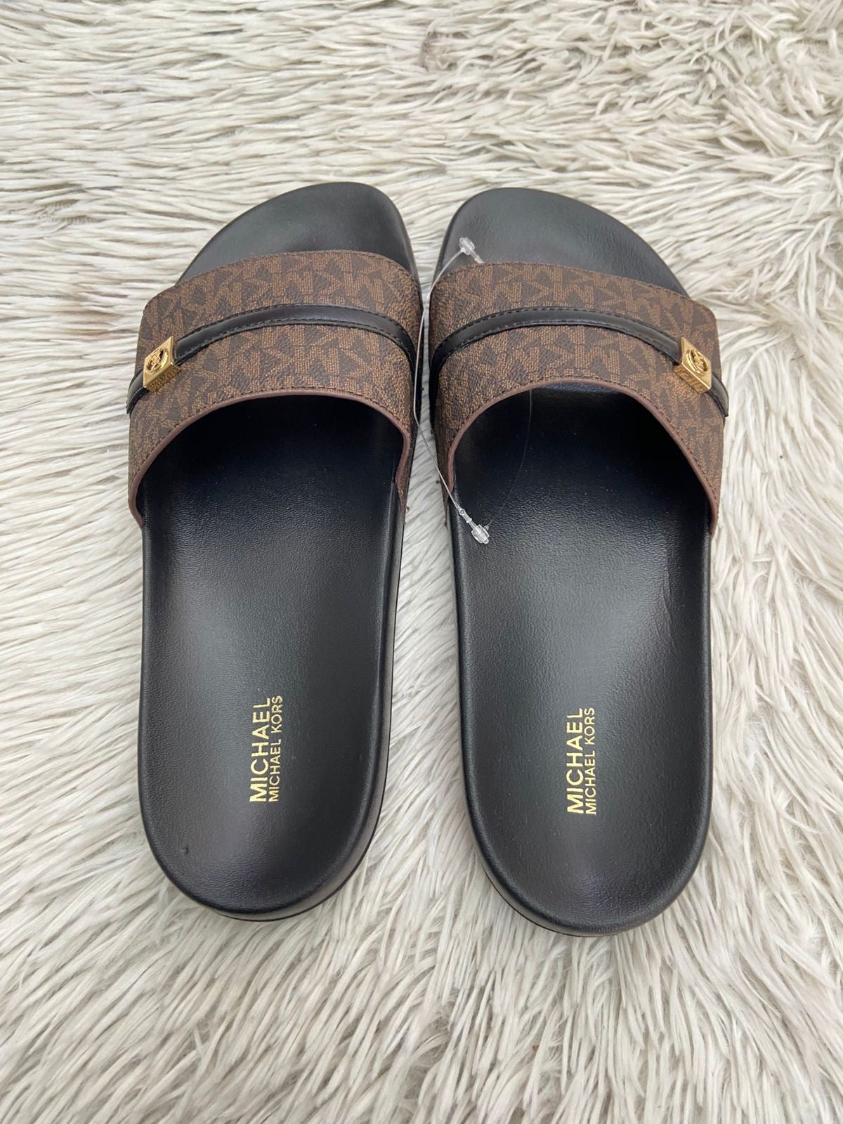 Sandalias MICHAEL KORS original, negra con marrón y correa en frente con placa MK en dorado.