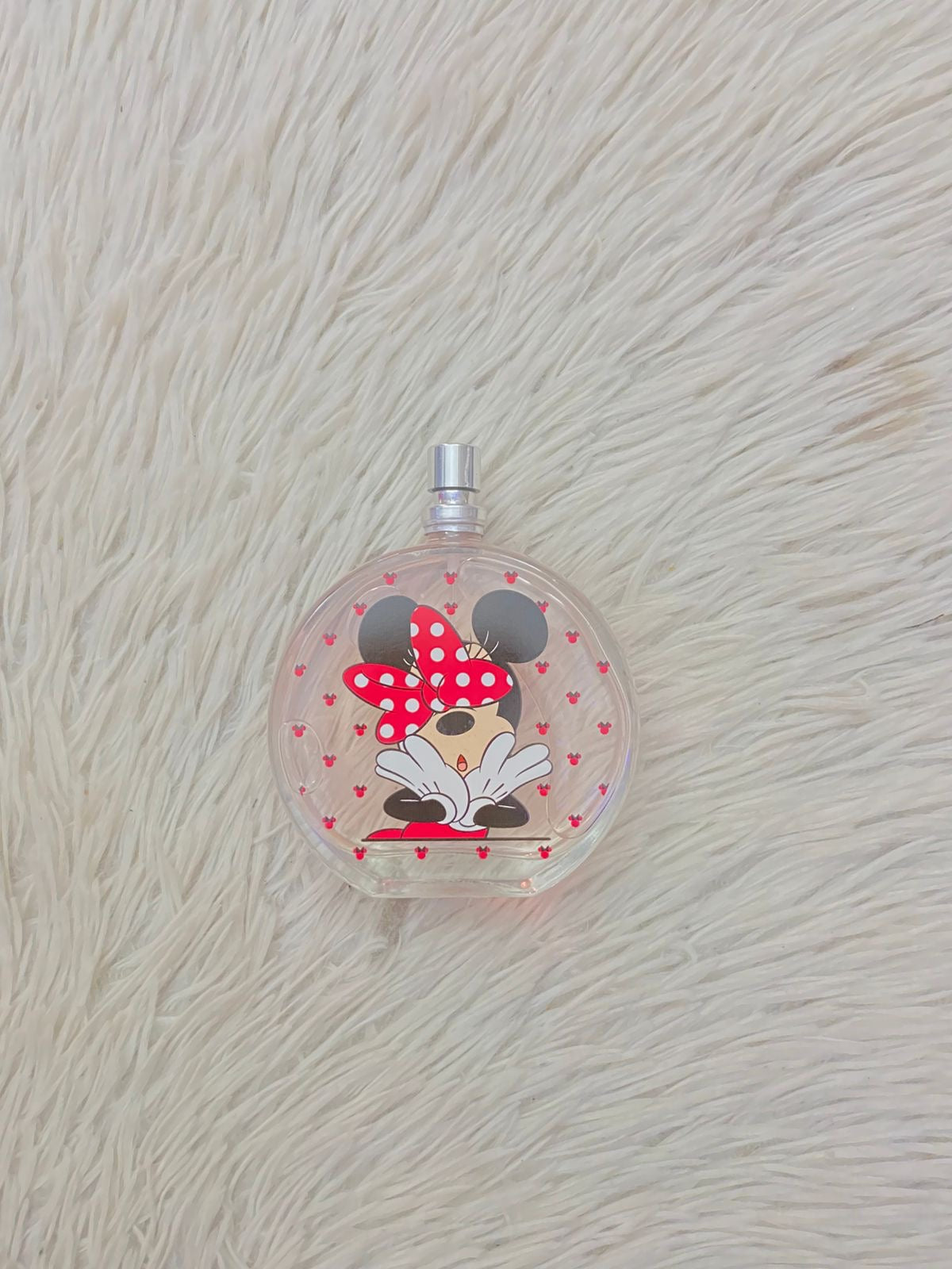 Perfume para niñas redondo con estampado de MINNIE MOUSE y fondo con iconos rojos.