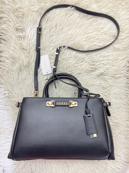 Cartera GUESS Original, color negra con placa de la marca al frente en color rosado, correa delgada adicional y accesorios en color dorado, varios compartimos.