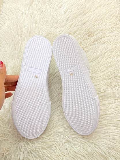 Tenis GUESS original blanco con detalles en color dorado y placa GUESS en dorado.
