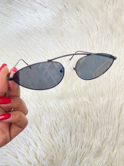 Lentes, negros pequeños con micas claras y montura fina.