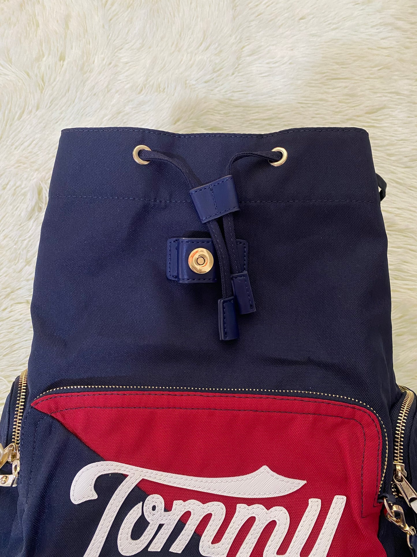 Mochila Tommy Hilfiger original en color azul marino, nombre TOMMY en grande en un bolsillo con el fondo rojo, varios compartimentos, súper espacioso.