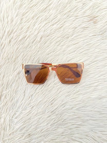 Lentes, diseñados con protección UV 100-400 para proteger tu visión. Marrón con montura en dorado y micas marrones.