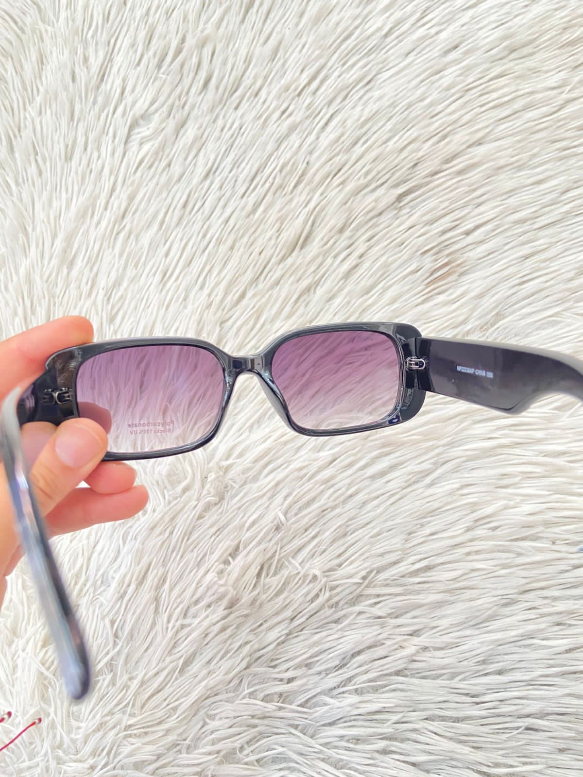 Lentes, negro con micas claras y montura en color negro y detalles en color dorado.