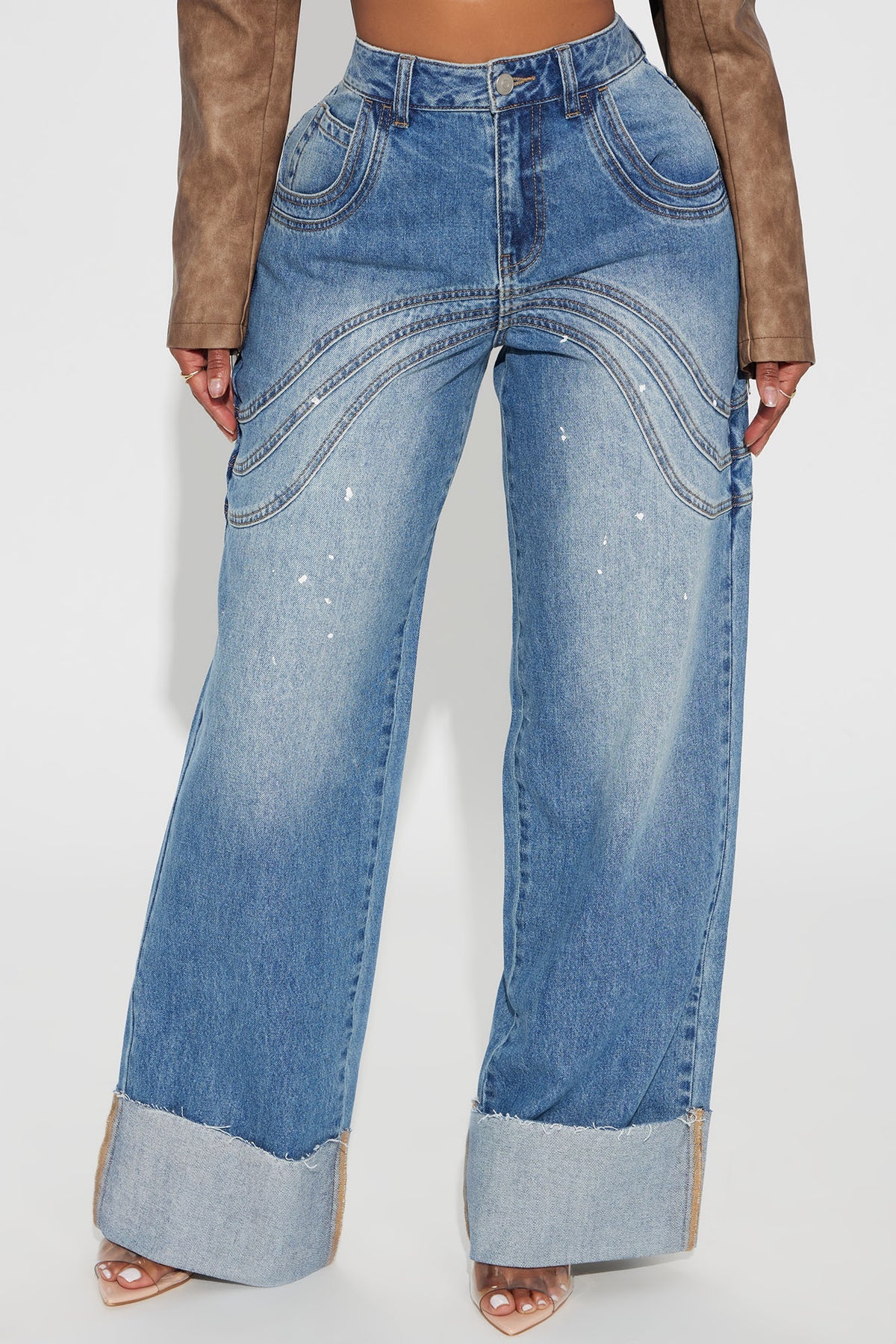 Pantalon jean azul con deslavado medio, detalle de algunas salpicaduras en color blanco, costuras decorativas alante y atras y doblado abajo.