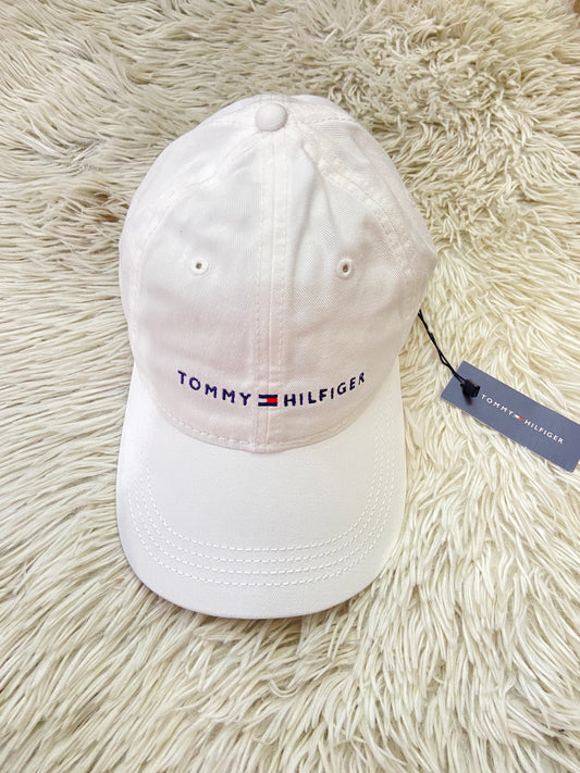 Gorra Tommy Hilfiger original blanca con letras TOMMY HILFIGER en azul y correa en marrón.