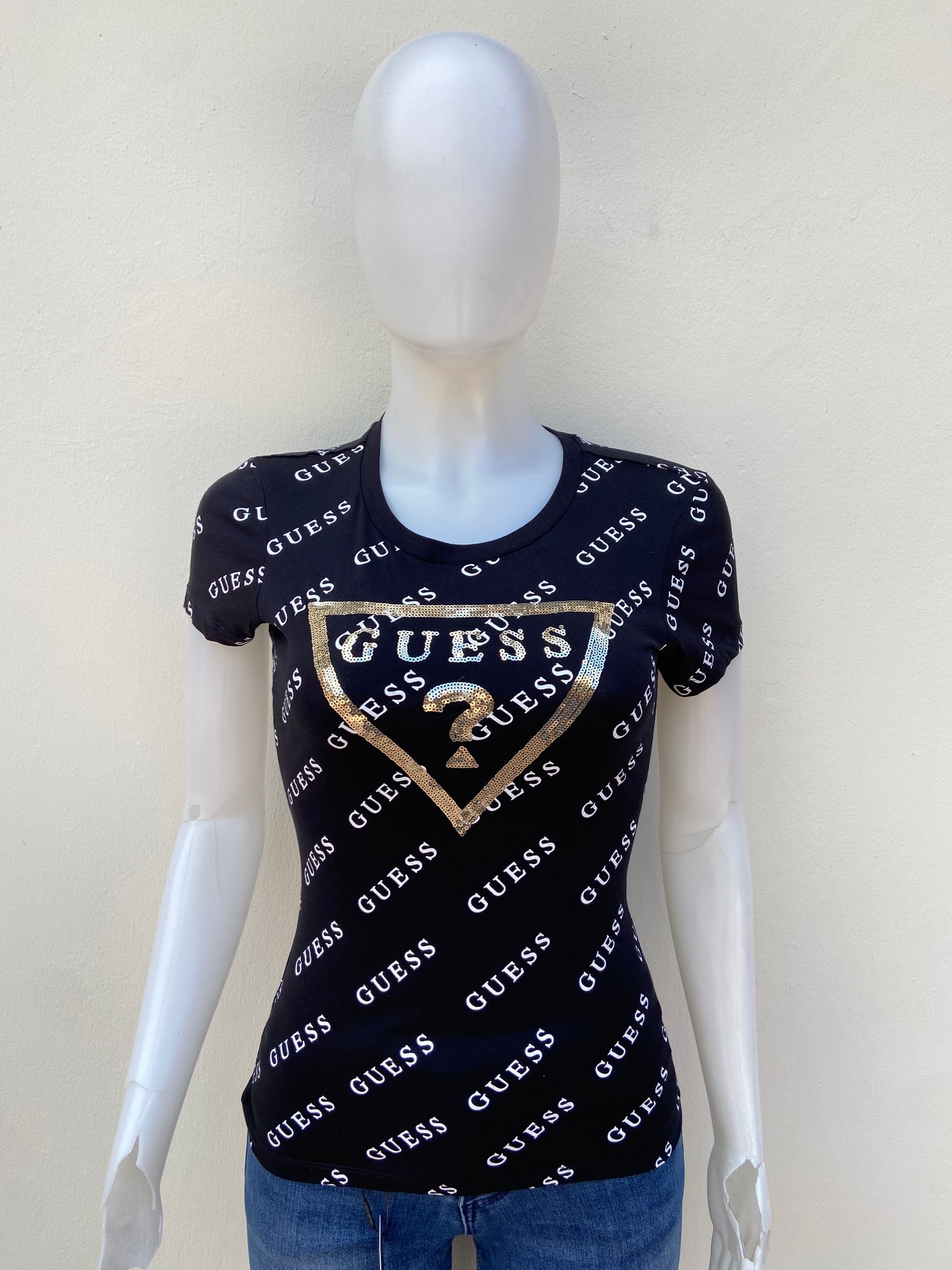 T-shirt GUESS original, negro con estampado de otras GUESS en blanco y triángulo en dorado con su logo.