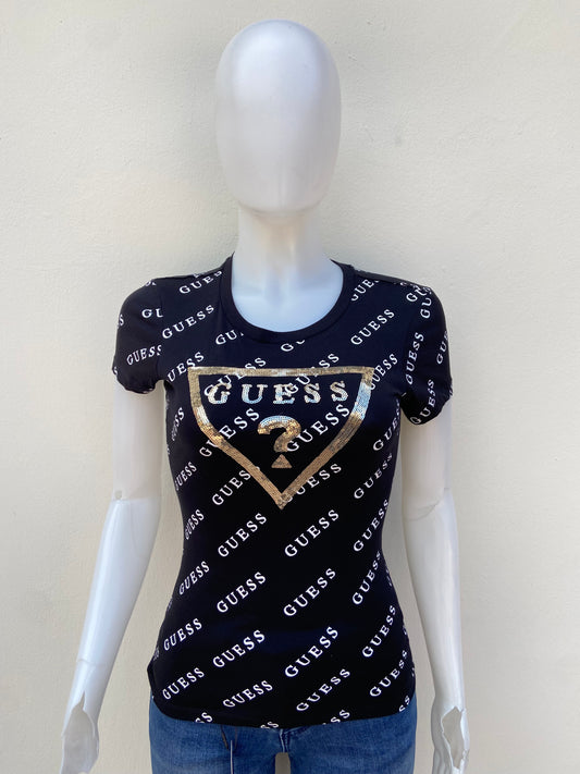 T-shirt GUESS original, negro con estampado de otras GUESS en blanco y triángulo en dorado con su logo.