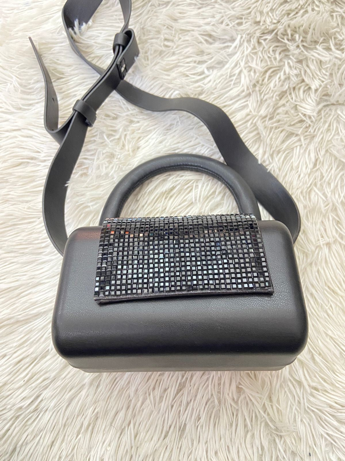 Cartera negra con detalles de brillo y correa de cuero