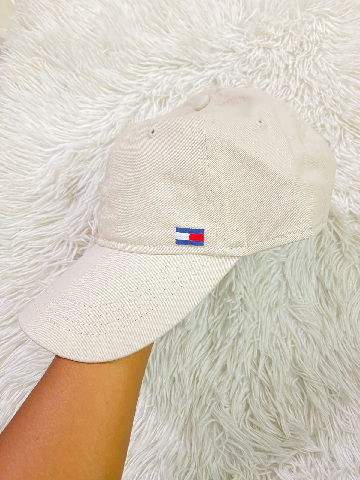 Gorra Tommy Hilfiger original crema con pequeño logotipo Tommy en la esquina y letras HILFIGER en azul.