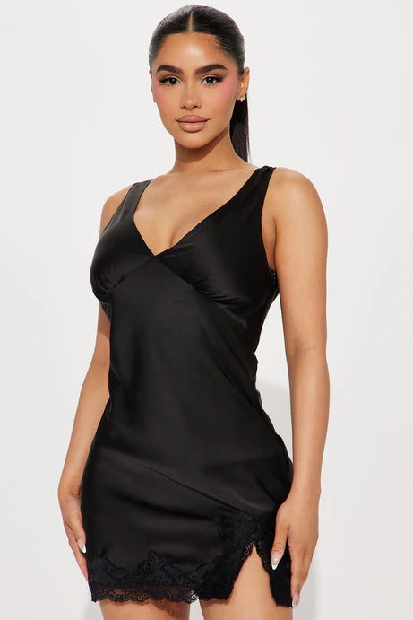 Vestido negro, escote en V y encaje en la parte inferior.