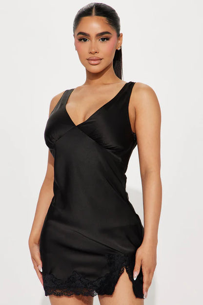 Vestido negro, escote en V y encaje en la parte inferior.